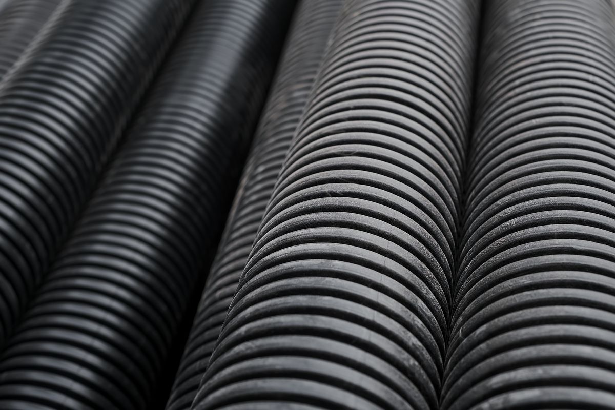 Gaines annelées noires en plastique, posées côte à côte et photographiées en gros plan.