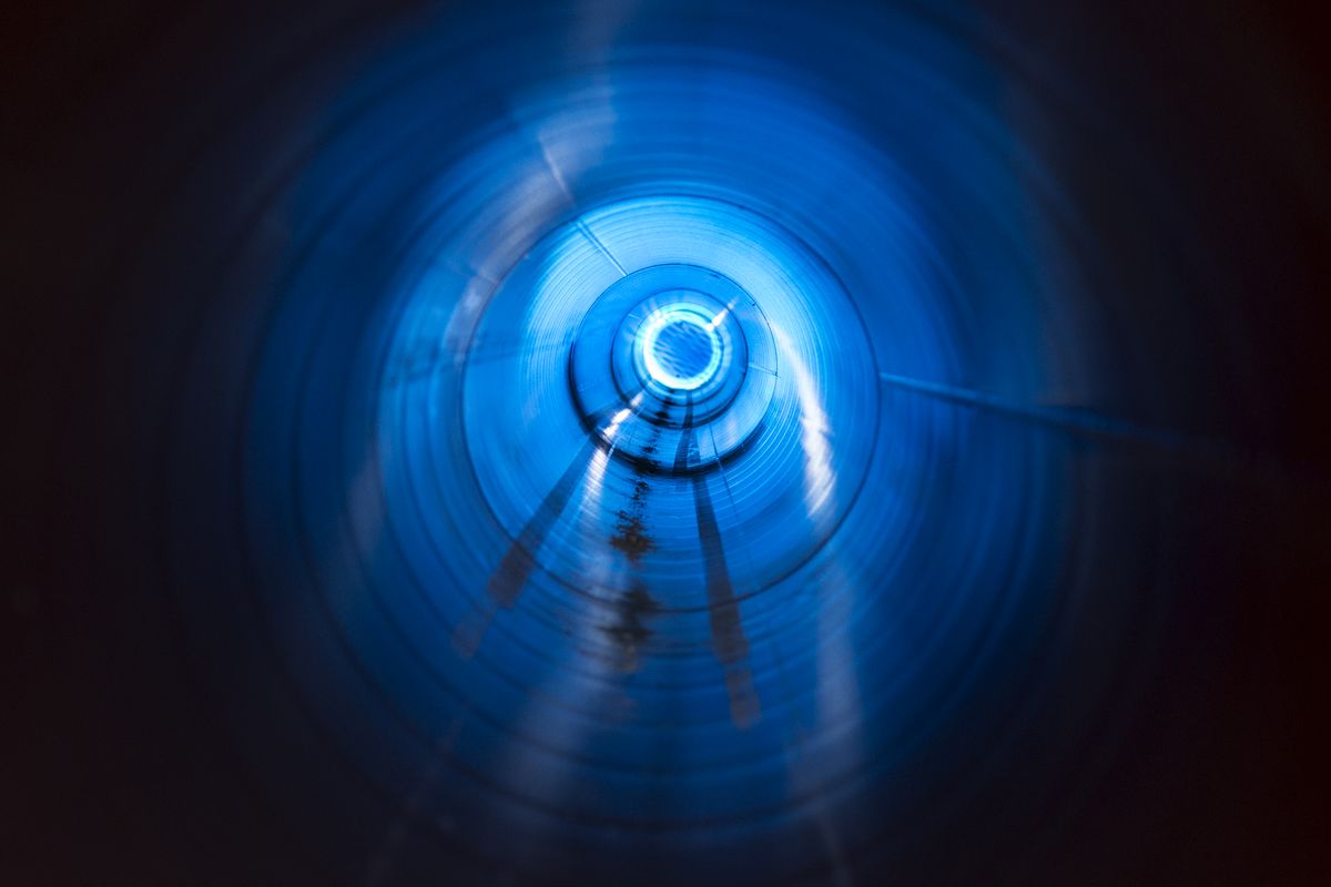 Intérieur d'une conduite éclairée en bleu, vue dans l'axe jusqu'au point de fuite